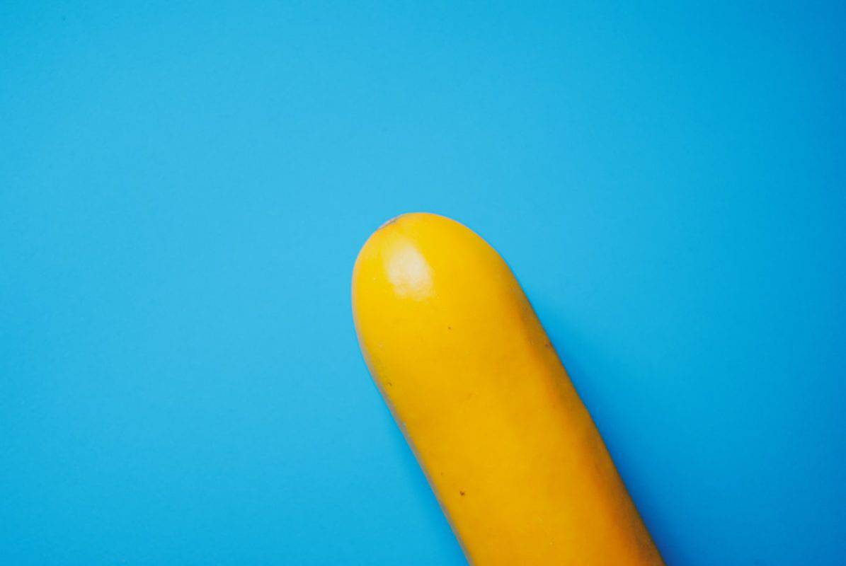 O objetivo da Omens é dar explicações sobre a falta de sensibilidade do pênis e suas possíveis causas. A imagem mostra uma abobrinha amarela que lembra o formato de um pênis nem um fundo azul.