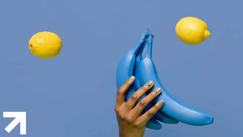 mão segurando banana pintada de azul