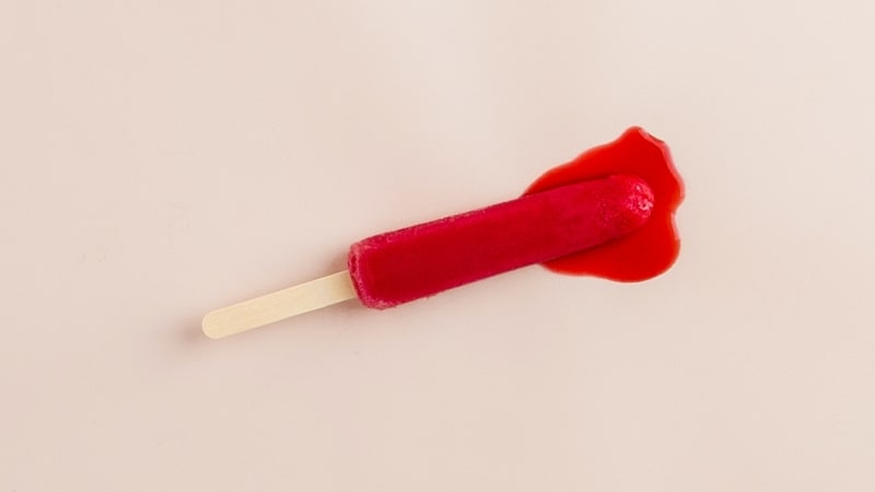 Um picolé derretendo, todo vermelho cor de sangue, representando o problema no esperma