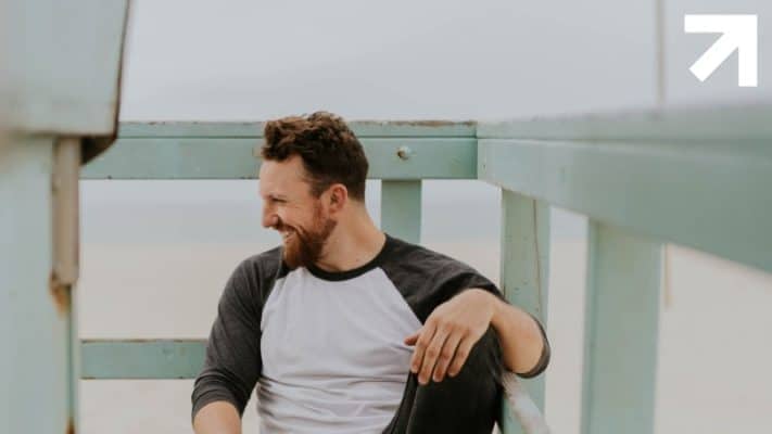 homem feliz na sacada com uma possível calvície controlada