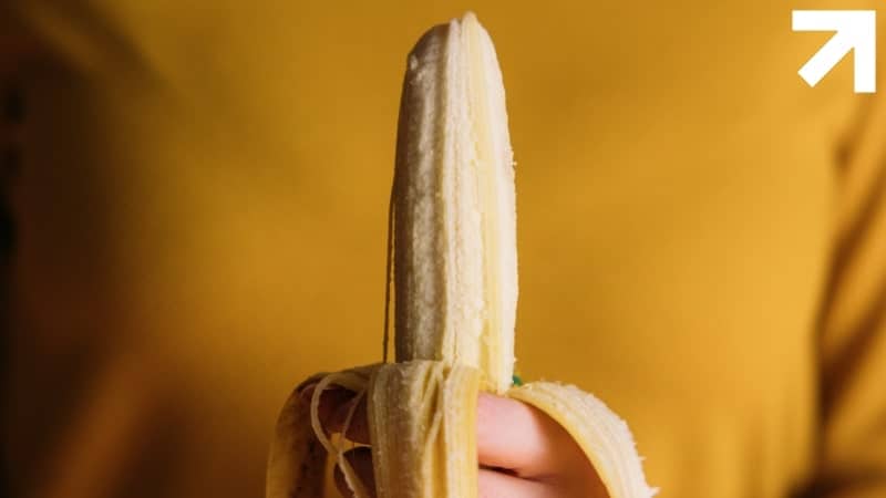 mulher segurando uma banana descascada sem fimose