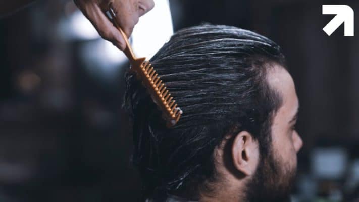 homem aplicando trichoxidil manipulado no cabelo com um pente