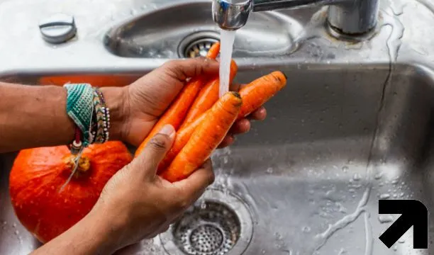 lavando legumes fálicos na pia