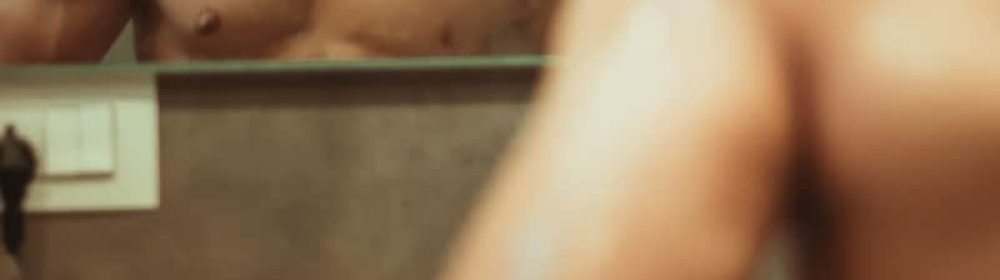 homem observando seu corpo no espelho